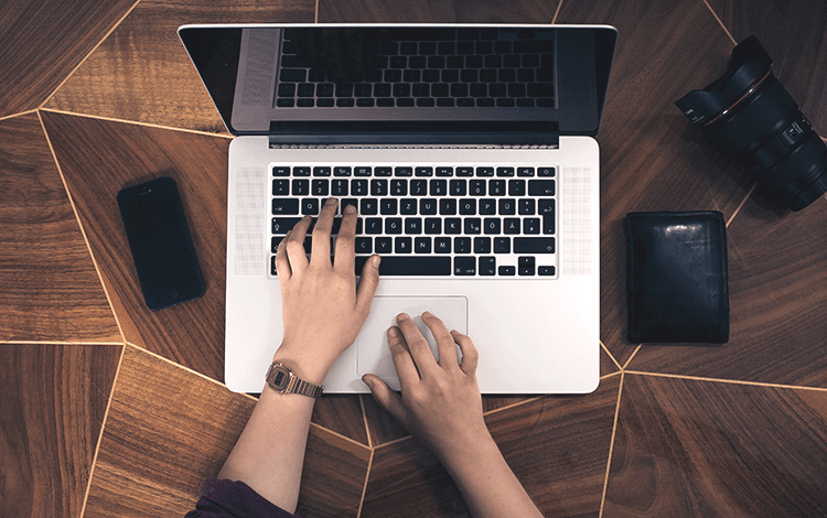 person writing on a macbook